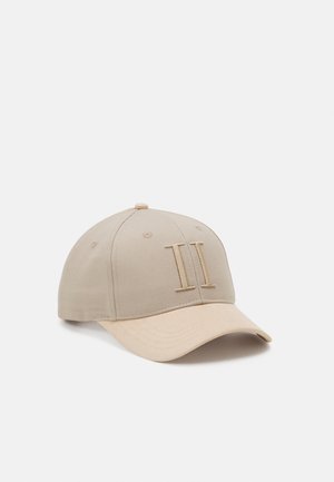 Beige baseballpet met een licht gebogen klep en verhoogd geborduurd Romeins cijfer II op het voorpaneel.