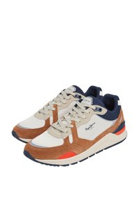 Zapatillas de ante marrón y malla blanca con acentos azules, cordones beige y un detalle rojo en el talón. Punta redondeada y suela acolchada.