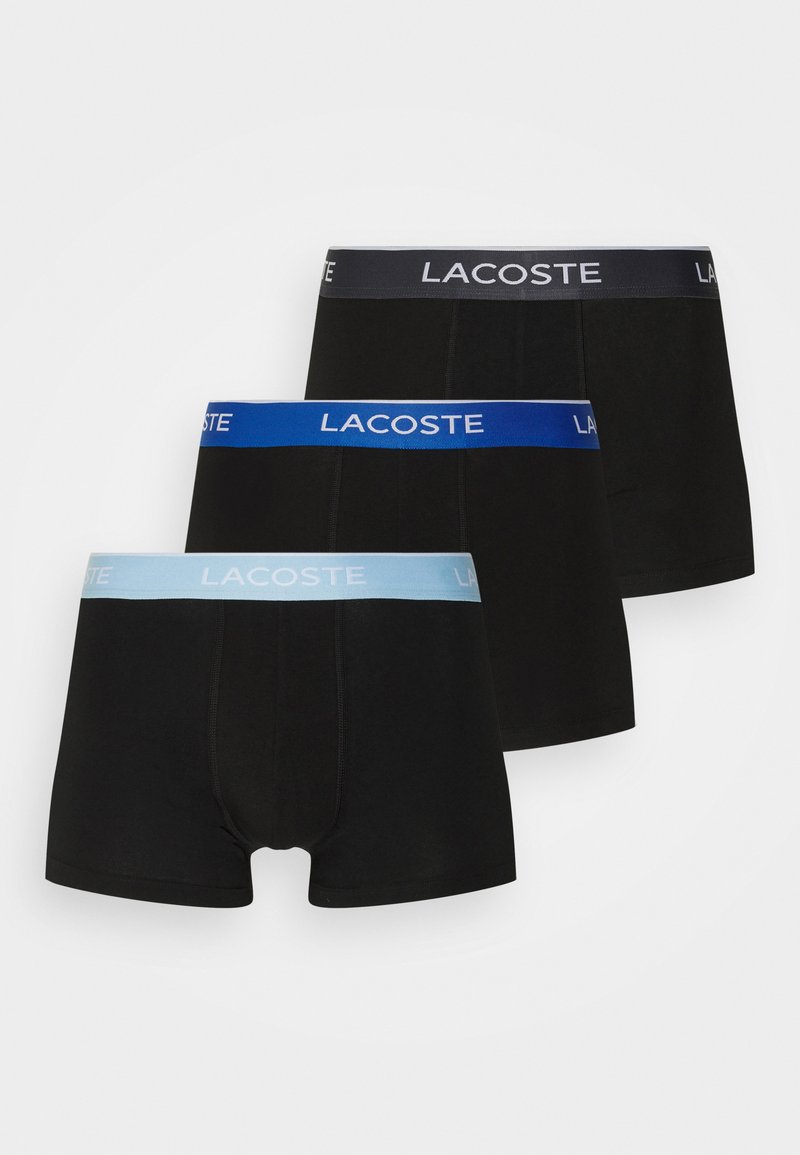 Conjunto de bóxers negros, con una cinturilla elástica de color gris oscuro, azul y azul claro con el logo "LACOSTE". Textura de tela suave.