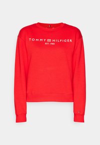 Czerwona bluza wykonana z mieszanki bawełny, z ściągaczami na rękawach i dole. Z przodu znajduje się logo "TOMMY HILFIGER" z datą założenia 1985.