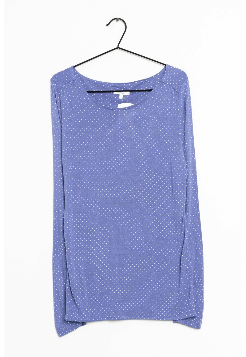 Blusa de manga larga azul con cuello redondo y lunares blancos. Tejido suave con un corte relajado y dobladillo redondeado, colgando de un gancho negro.