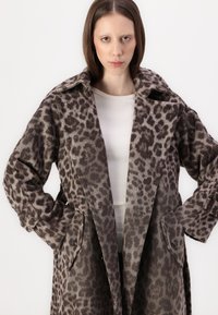 Leopardmønstret frakk i mykt stoff, med notched krage, knappelukk og store frontlommer. Farge: brune og beige toner.