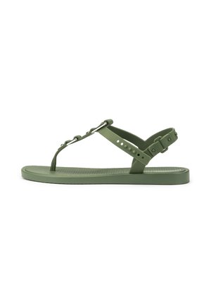 Grüne flache Sandale mit verstellbaren Riemen am Knöchel und an den Zehen, mit kleinen Metallnieten und einer strukturierten Sohle.