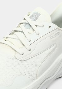 Hvide sneakers med en kombination af glat læder og struktureret ruskind, med et mønstret strikdesign, flade snørebånd og diskrete brandingelementer.