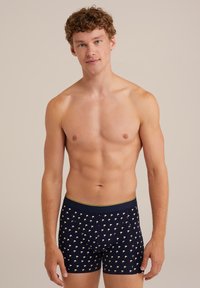 Kalsonger i marinblått med ett mönster av små gula och vita fåglar. Mjukt material med ett elastiskt midjeband, som har kontrasterande gröna kanter.