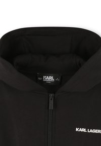 Sweat à capuche zippé noir pour enfants, en tissu texturé, avec une capuche et un logo blanc "KARL LAGERFELD KIDS" sur le devant.