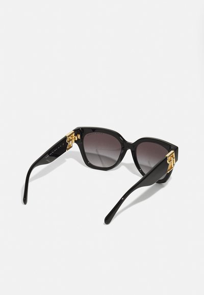 Black sunglasses with a geometric design, gradient lenses, and gold hardware accents on the temples. Smooth plastic texture.