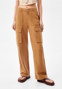 Cargo byxor i en varm brun färg, tillverkade av bomull med en avslappnad passform, med flera sidofickor och rak bendesign.