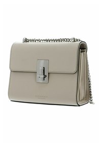 Sac à main en cuir beige avec une bandoulière chaîne argentée, forme rectangulaire, fermeture à rabat et un détail de serrure métallique brillante.