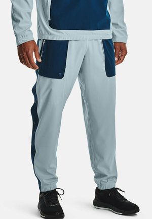 Lichtblauwe sportbroeken met marineblauwe accenten, voorzien van drukknoopzijden, elastische boorden en twee voork ontdekt.
