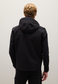 Schwarze Kapuzenjacke mit glatter, wasserabweisender Textur. Minimalistisches Design und taillierte Passform. Keine sichtbaren Beschläge oder Verzierungen.