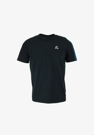 Camiseta de manga corta en algodón azul oscuro con un cuello redondo y acentos en verde oscuro en los hombros. Presenta un pequeño logo en el pecho.