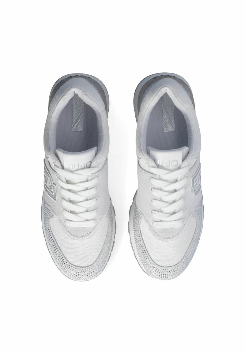 Witte sportieve schoenen met een bovenwerk van mesh en textiel, vetersluiting, gewatteerde kraag en grijze accenten langs de zool en zijkanten.