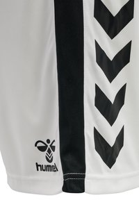 Maglietta sportiva bianca con accenti neri, inclusi motivi a chevron e un logo. Realizzata in un tessuto liscio; design a maniche corte.