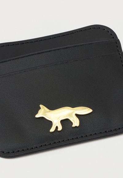 Μαύρος δερμάτινος θήκη καρτών με χρυσή διακόσμηση σε σχήμα αλεπούς. Διαθέτει πολλαπλές θήκες καρτών και αντίθετη ραφή γύρω από τις άκρες.