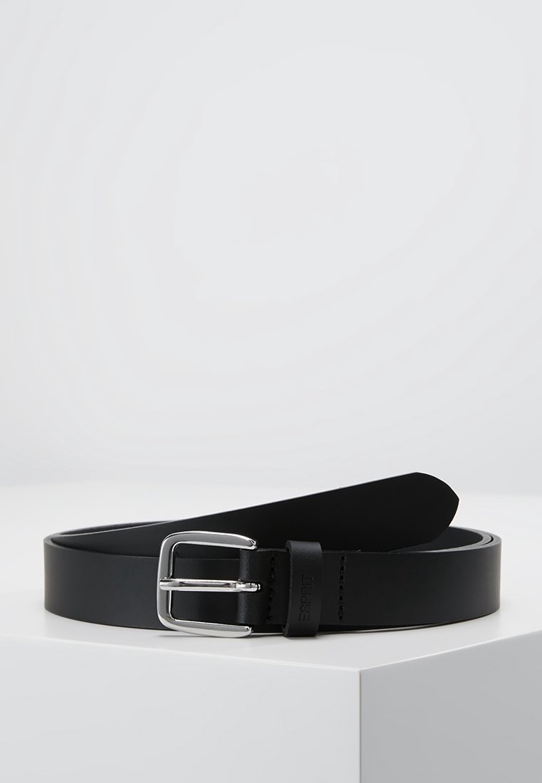 Ceinture en cuir noir avec une boucle rectangulaire argentée, roulée et placée sur une surface blanche sur un fond clair uni.