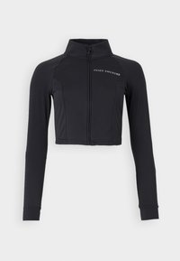 Čierna skrátená bunda vyrobená z elastického materiálu, s vysokým golierom, dlhými rukávmi a predným zipsom s bielym logom "JUICY COUTURE".
