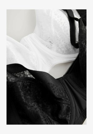 Dos sujetadores expuestos: uno negro con detalles de encaje y acentos de malla, y otro blanco con un acabado liso. Ambos cuentan con aros y tirantes ajustables.