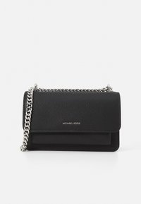 Schwarze Leder-Crossbody-Tasche mit strukturiertem Finish, silberfarbener Kettenriemen, Klappenverschluss und geprägtem Logo auf der Vorderseite.