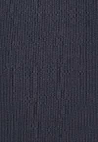 Tissu côtelé bleu marine foncé avec une surface texturée, présentant un motif régulier de lignes verticales et de fils entrelacés.