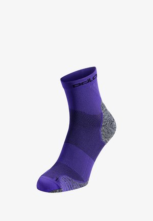 Lila SportSocke mit strukturiertem Design, grauem Fersen- und Zehenbereich sowie schwarzem Logo am Bündchen. Mittlere Wadenlänge mit verstärkten Bereichen.