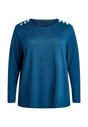 Maglietta a maniche lunghe di colore blu teal con scollatura tonda e sei bottoni floreali bianchi decorativi, tre su ciascun spalle.