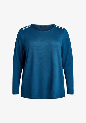 Maglietta a maniche lunghe di colore blu teal con scollatura tonda e sei bottoni floreali bianchi decorativi, tre su ciascun spalle.