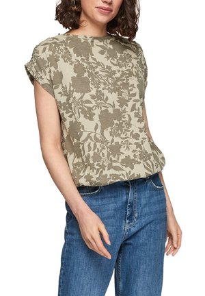 Let, beige blomstret top med korte ærmer, tekstureret stof og en afslappet pasform, kombineret med blå denimjeans.