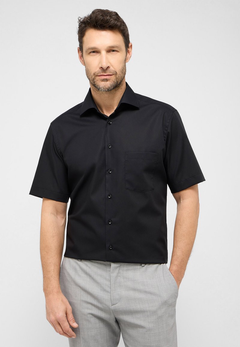 Zwarte short-sleeve shirt van gladde stof, met een knoopsluiting aan de voorkant, een spitse kraag en een enkele borstzak.