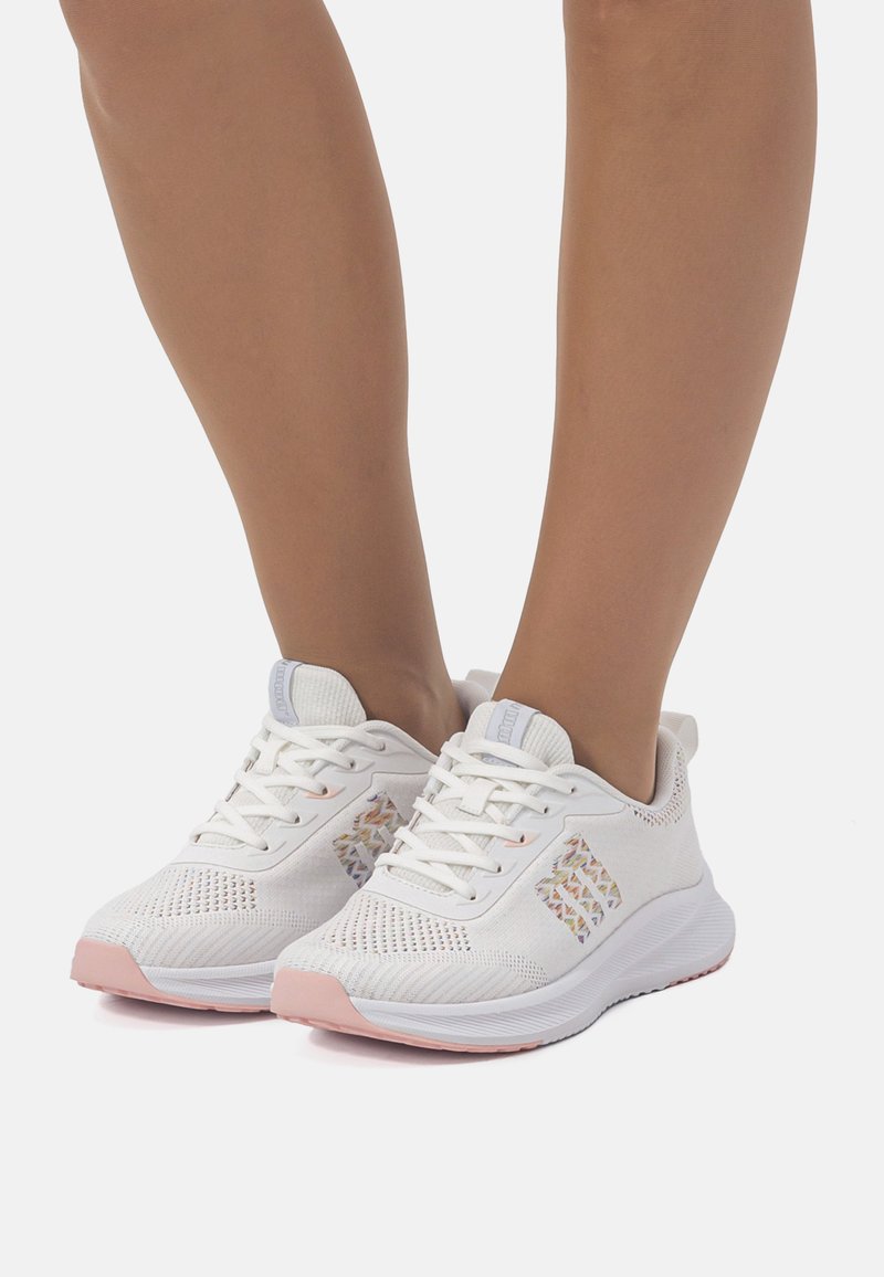 Zapatillas deportivas blancas con parte superior de malla transpirable, suela rosa pastel y acentos decorativos en los laterales. Incluye cordones y un collar acolchado.