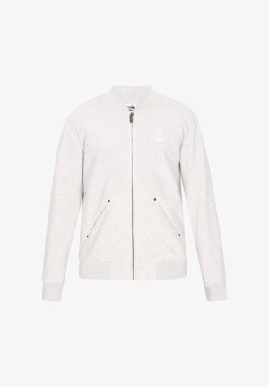 Světle šedá bomber bunda z měkké látky, s předním zapínáním na zip, dvěma bočními kapsami a jemným kotvičkovým logem na hrudi.