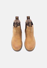 Bottines en cuir marron avec des panneaux élastiques sur les côtés, doublure en fourrure et languettes de tirage. Semelle plate en caoutchouc avec un motif texturé.