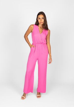Une combinaison sans manches rose vif avec un col en V, une taille élastique et des pantalons évasés. Tissu lisse et léger avec des poches latérales.