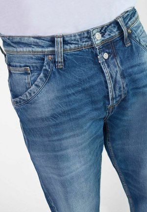 Jeans aus Denim in einer hellblauen Waschung verfügen über ein klassisches Fünf-Taschen-Design, mit sichtbaren Nähten und einem Knopfverschluss.