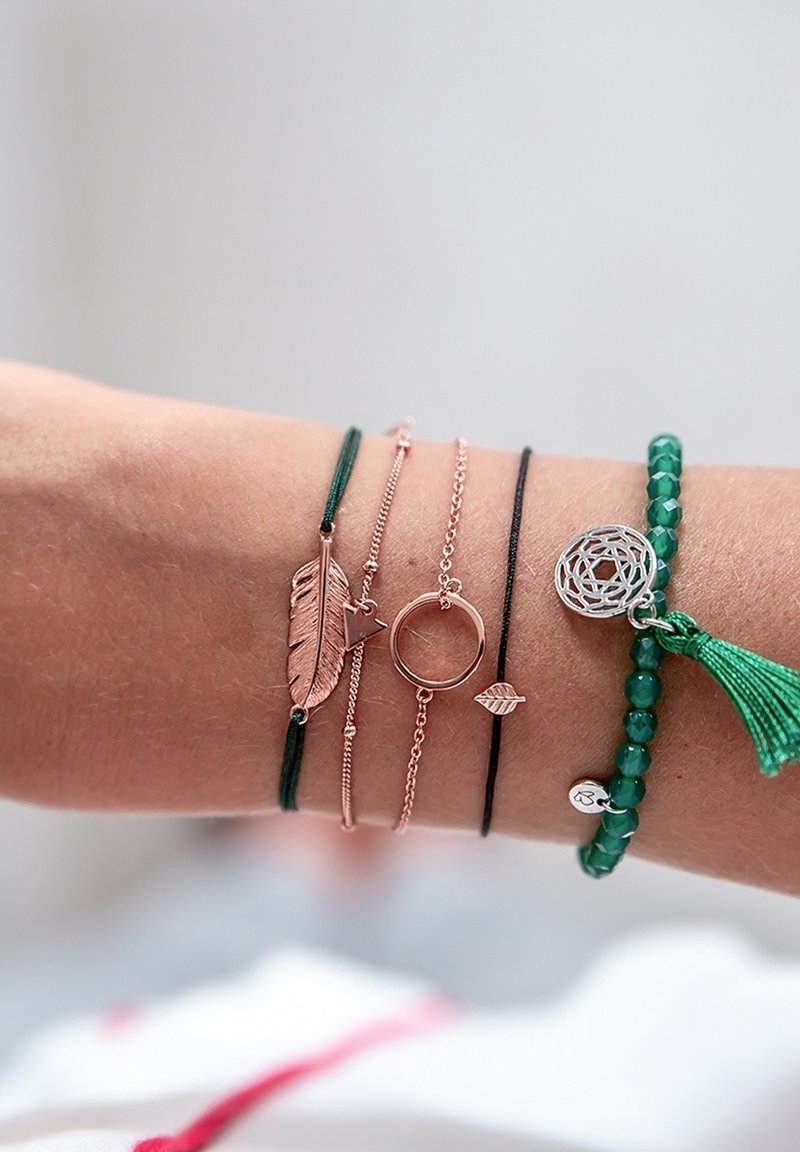 Ceturto rokassprādze komplekts: rozā zelta plāna ķēde, zaļa aukla ar spalvas piekariņu, melna aukla ar lapas piekariņu, zaļo pērļu rokassprādze ar pušķi.