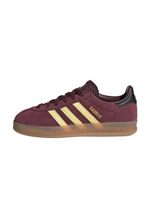 Maroonfarbener Adidas Gazelle Sneaker mit gelben Streifen, strukturiertem Zungenbereich, schwarzem Fersenlasche und durchsichtiger Gummisohle.
