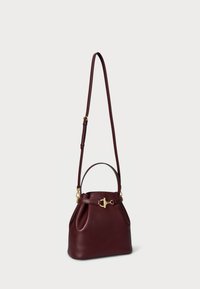 Burgundowa skórzana torebka na ramię z złotym zapięciem, krótką rączką i regulowanym długim paskiem. Posiada miękką, ustrukturyzowaną sylwetkę oraz marszczone boki.