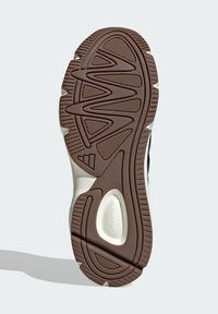 Sneakerová podrážka s hnedou gumovou základňou, ktorá má cik-cak a kruhové dezénové vzory, a bielu medzipodrážku s brandingom "CLOUDFOAM".