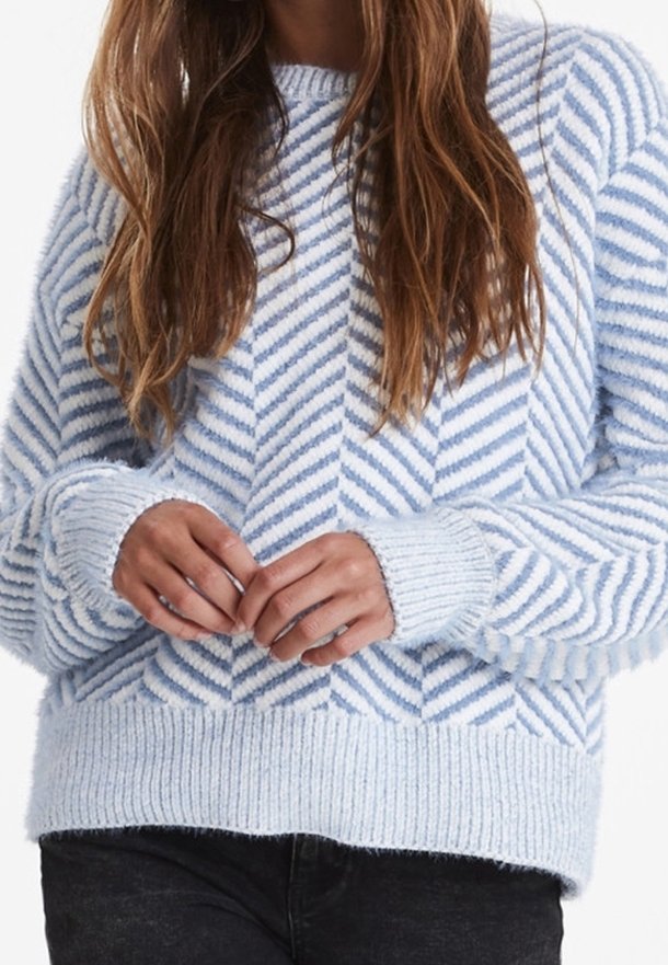Pull bleu clair avec un motif en chevron texturé et des rayures alternées. Manches et ourlet côtelés, tissu doux, coupe ample.