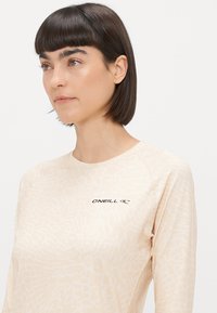 Beezik pikka varrukatega topp, millel on diskreetne tekstuuriline muster ja raglan varrukad. Rinnal on väike must O'Neilli logo.