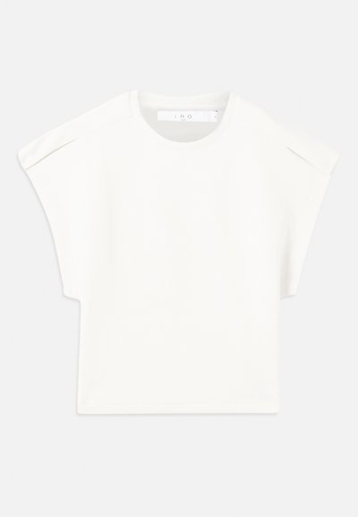 Balta kaste formas T-kreklā ar īsām piedurknēm. Izgatavots no gluda auduma, ar apaļu izgriezumu un nelieliem plecu akcentiem. Vienkāršs dizains.