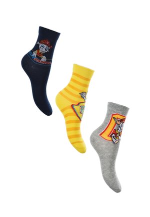 Trois paires de chaussettes pour enfants : bleu marine avec un chien de dessin animé et du texte, rayées jaunes avec un chien de dessin animé, et grises avec un autre design de chien de dessin animé.