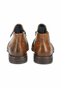 Botas de tobillo de cuero marrón con acabado texturizado, con cremallera trasera y tirador de tela navy en contraste. Suela de goma marrón resistente.