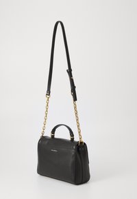 Borsa a mano in pelle nera con un design strutturato. Caratterizzata da una tracolla in catena dorata e una maniglia superiore. Texture liscia con dettagli di marchio minimi.