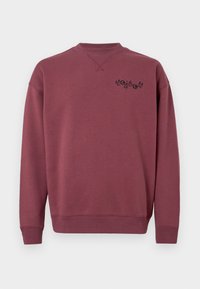 Sweatshirt en coton bordeaux avec un col rond et des poignets côtelés. Présente un logo noir imprimé sur la poitrine gauche. Texture lisse.