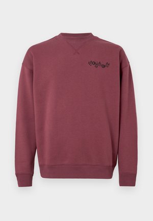 Bordeaux katoenen sweatshirt met een ronde halslijn en ribgebreide mouwen. Heeft een zwart logo gedrukt op de linkerborst. Glad textuur.