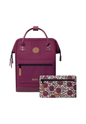 Lila Stoff-Rucksack mit glatter Textur, ausgestattet mit zwei oberen Griffen, einer vorderen Reißverschlusstasche und einem abnehmbaren, gemusterten Täschchen mit floralem Design.