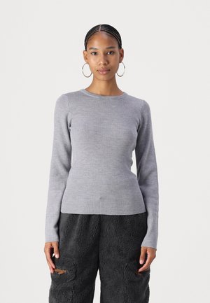 Grå langærmet ribstrikket sweater med rund halsudskæring, tætsiddende form og blød tekstur, parret med sorte fuzzy bukser med lommer.