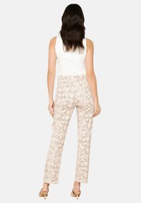 Pantalons beiges légers avec un motif serpent texturé, taille haute, coupe droite et finition lisse.