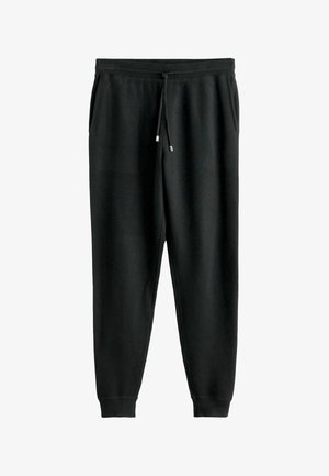 Melni svārki ar regulējamu jostu, sānu kabatām, sašaurinātiem līkumiem un ribotām aprocēm. Izgatavoti no mīksta auduma ar gludu tekstūru.